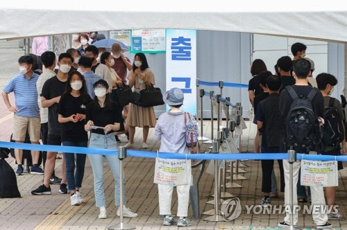 지난 6일 오전 서울 마포구 서강대역 환승공영주차장 인근에 마련된 코로나19 임시선별검사소에 시민들이  검진을 받기 위해 줄을 서고 있다. <연합뉴스>